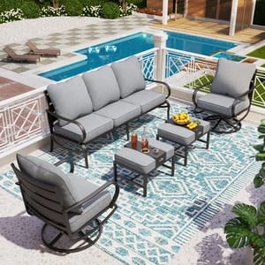 Outdoor patio furniture set including a sofa, two rocking chairs, and two square tables with cushions on a patterned rug.