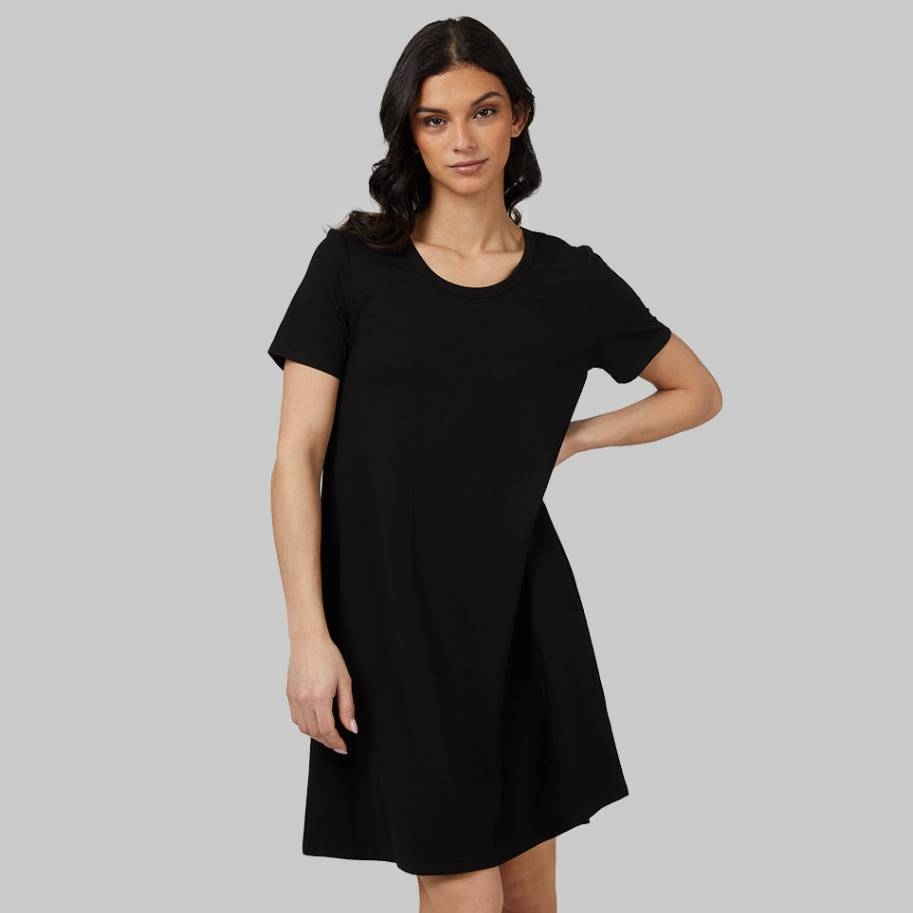 A woman wearing a short-sleeved black dress with a round neckline.