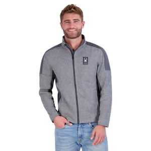 Spyder Men's Mendoza Pullover is a gray zip-up fleece with dark gray shoulder and arm accents, featuring the Spyder logo on the chest. It is paired with light blue jeans and designed for comfort and style.