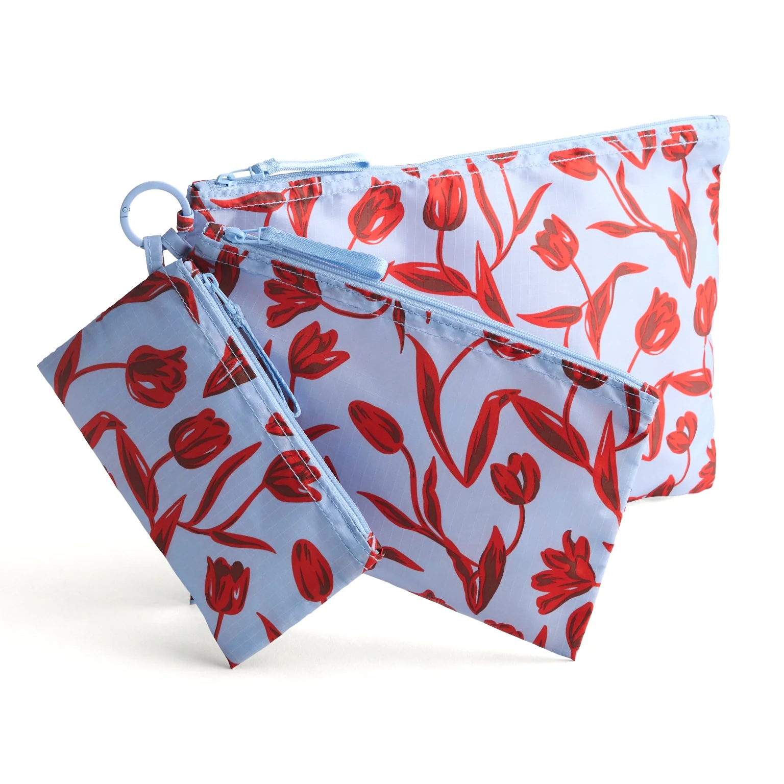Set of three light blue zippered pouches with red tulip patterns, featuring varying sizes connected by a ring.