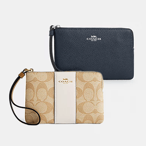 Two Coach wristlets, one navy blue and one beige with signature brand print.
