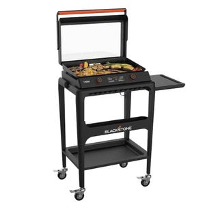 A Blackstone griddle with a cart features a flat-top cooking surface, a bottom shelf, side prep table, a hood cover, and is mounted on four caster wheels for mobility.