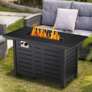 Black propane fire pit table with a rectangular design, featuring an adjustable flame and control knobs, set outdoors next to rattan patio furniture with cushions.