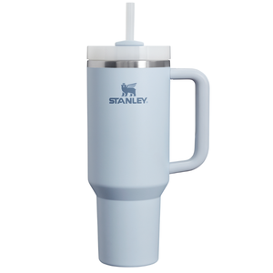 A light blue 40oz Stanley Tumbler with a handle, stainless steel rim, and a clear lid featuring a straw. The brand's logo is displayed on the front.