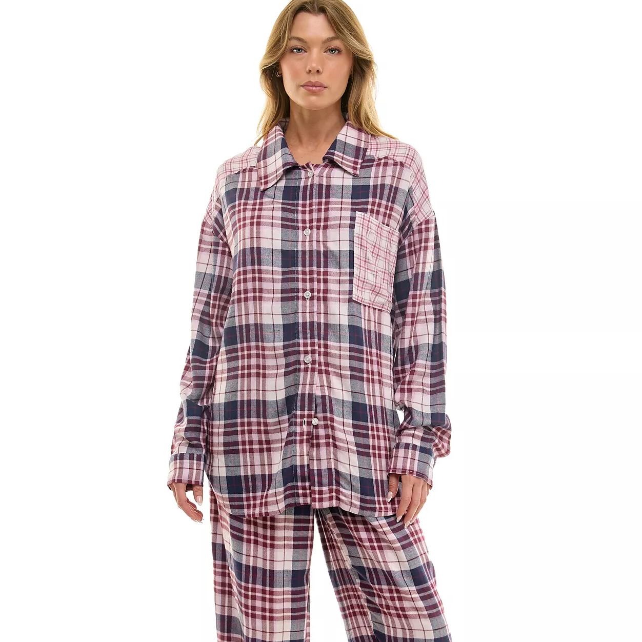 A model wears a long-sleeve plaid button-up shirt and matching pants in shades of red, purple, and white.