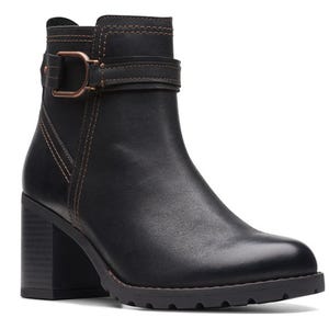 Black ankle boot with a block heel, strap, and buckle detail, featuring contrasting stitching.