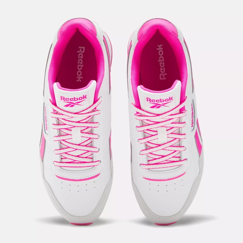 A pair of white Reebok sneakers with pink accents and laces.