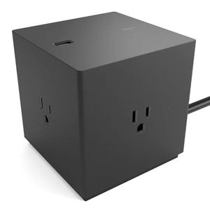 A black cube-shaped power strip with electrical outlets on multiple sides and a USB port on top.