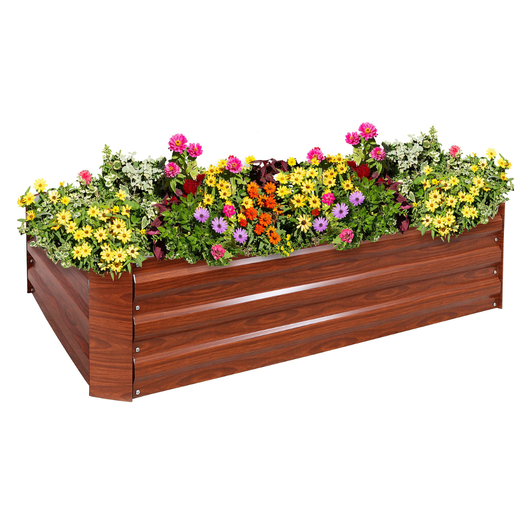 A wooden raised garden bed planter filled with colorful flowers, including yellow, pink, orange, and purple blooms, along with green foliage.