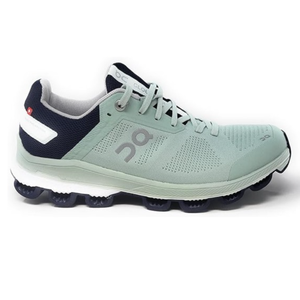 A mint green and navy athletic shoe with \“On\“ branding features a breathable mesh upper, lace-up closure, and a distinctive cushioned sole designed for comfort and performance.