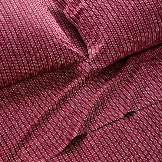 A set of dark red bedding with thin, vertical white stripes, including a flat sheet and pillowcases.