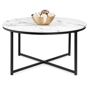 A round coffee table with a faux-marble top and black metal frame, featuring a modern X-shaped base. It holds a gold bowl with decorative orbs.