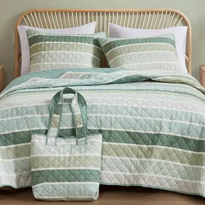 A quilted bedding set featuring green and white stripes includes a comforter, two pillow shams, and a matching carry tote.