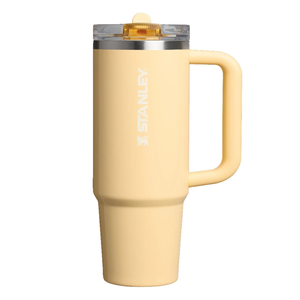 A yellow Stanley travel mug with a handle and clear lid, featuring the Stanley logo in white on the side.