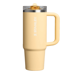 A yellow Stanley travel mug with a handle and clear lid, featuring the Stanley logo in white on the side.