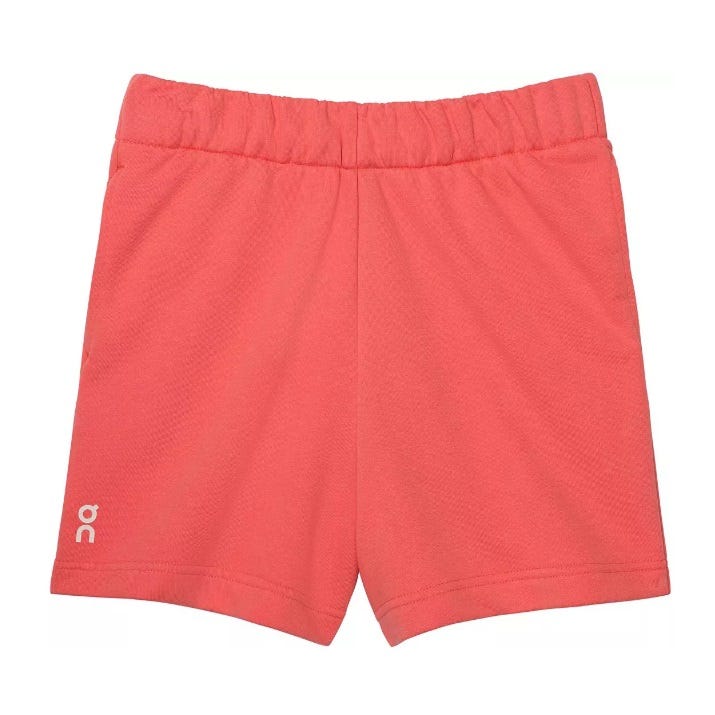 Coral-colored athletic shorts featuring an elastic waistband and a small \“OC\“ logo on the lower left.
