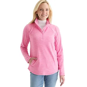 Woman wearing a pink quarter-zip pullover with a white turtleneck underneath and light blue jeans. The pullover features a front pocket and a relaxed fit.