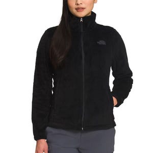 A woman wearing a black fleece jacket with a high collar and zip closure, paired with gray cargo pants.