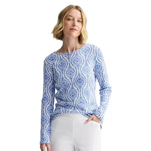 A woman is wearing a long-sleeve top with a blue and white patterned design and white pants.