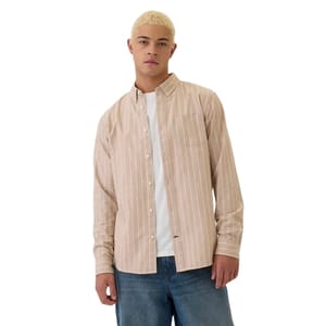 Men's button-up oxford shirt in light brown with white vertical stripes. Features a classic collar, single chest pocket, and long sleeves. Worn over a white T-shirt, paired with blue jeans.