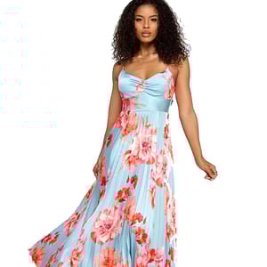 A woman wearing a sleeveless, blue maxi dress with pink and red floral prints, featuring a fitted bodice with spaghetti straps and a flowing pleated skirt.