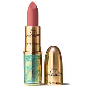 MAC x Disney Aladdin lipstick features a gold and turquoise tube with an intricate design. The lipstick itself is a muted pink shade, and the packaging displays the Aladdin and MAC logos.
