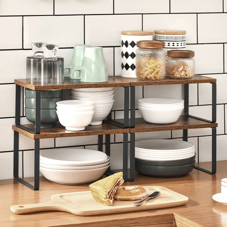 Kitchen scene featuring a wooden shelf with stacked dishes, jars, a mug, a cutting board with a sandwich and donut, and hanging utensils against a tiled backsplash.