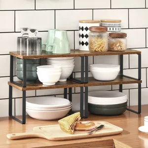 Kitchen scene featuring a wooden shelf with stacked dishes, jars, a mug, a cutting board with a sandwich and donut, and hanging utensils against a tiled backsplash.