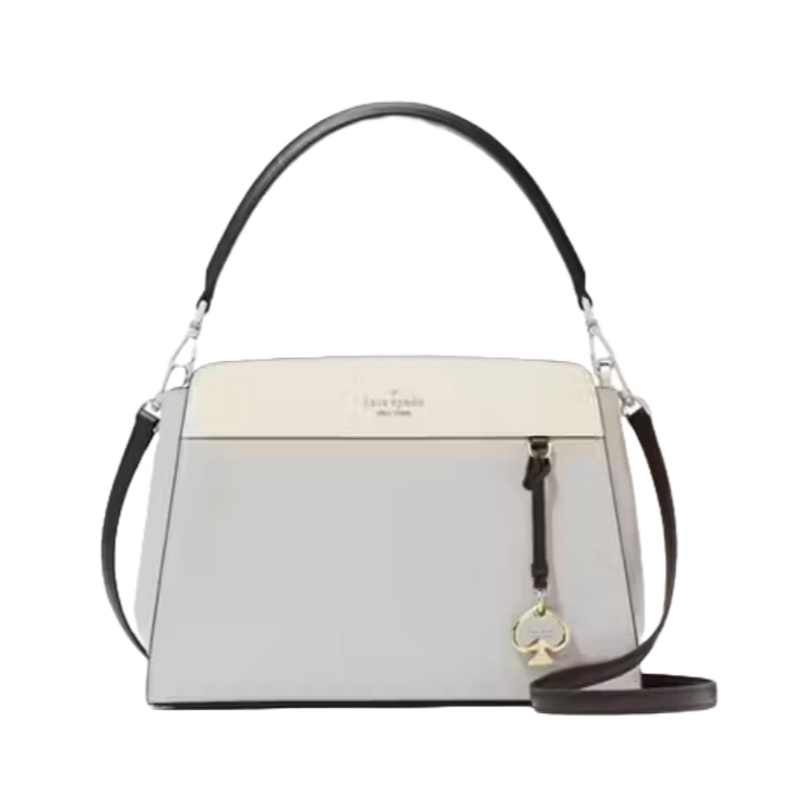 A two-tone handbag with a top handle and detachable shoulder strap, featuring a spade charm and subtle branding on the front.