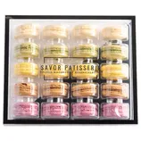 A box containing assorted French macarons from Savor Patisserie, featuring a variety of colors and flavors neatly arranged in a clear plastic case.