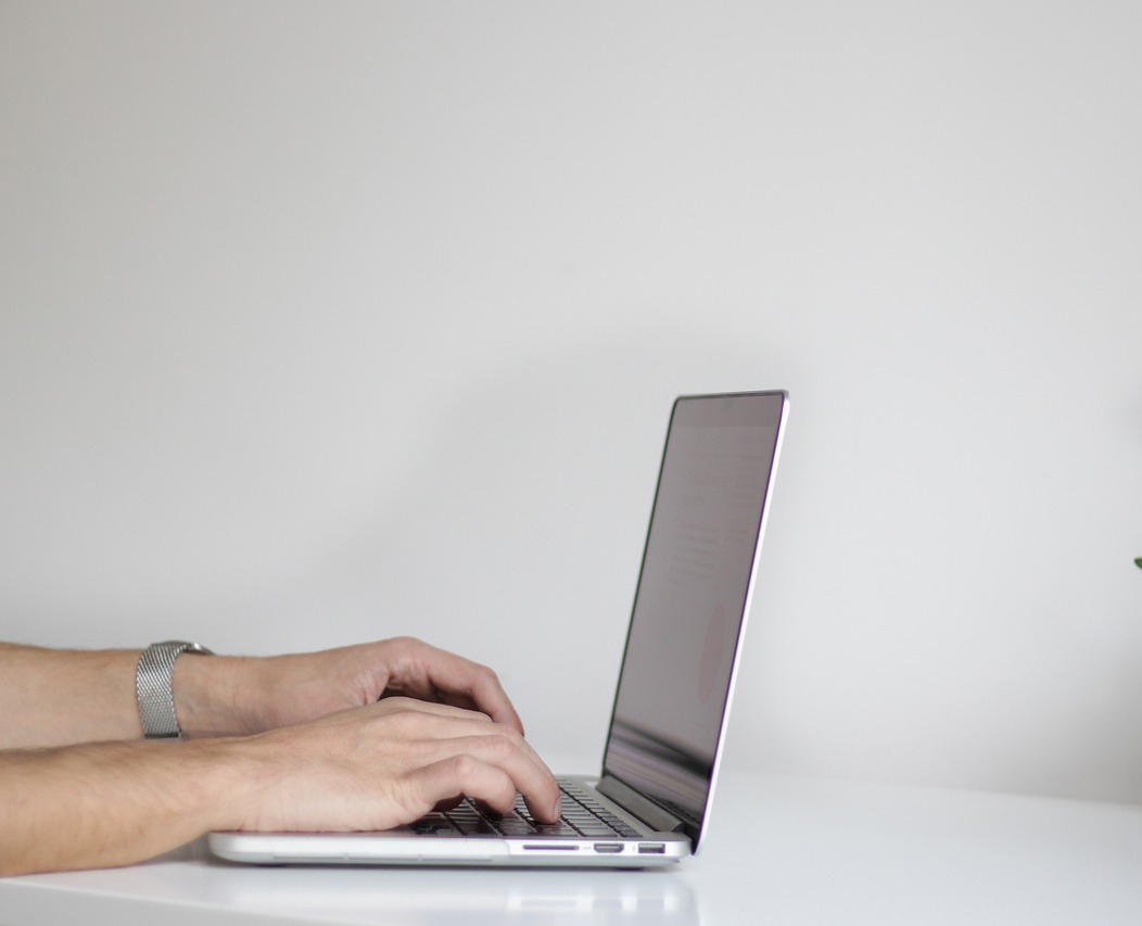 A laptop with a person typing on it.