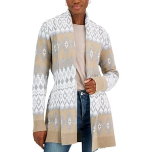 A woman is wearing a long-sleeved, knee-length Cozy Cardigan with a shawl collar, featuring a beige background with white and pale blue Fairisle pattern accents.
