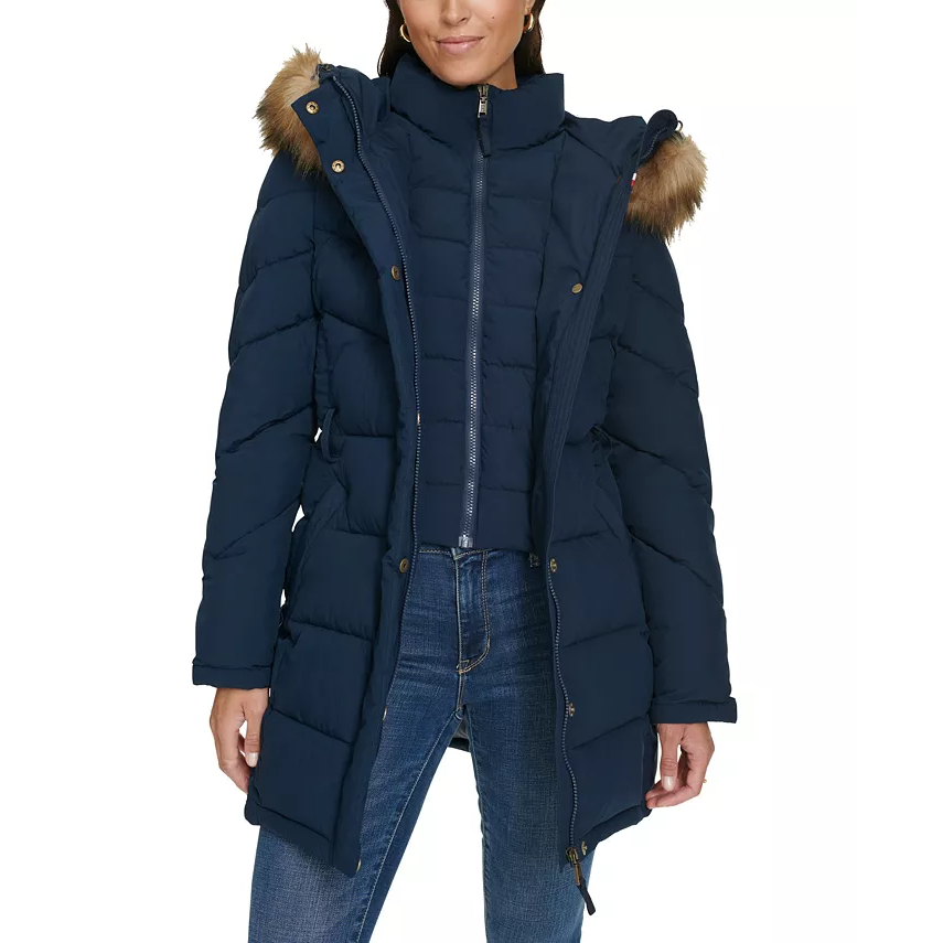A navy blue hooded puffer coat featuring a zippered front, side pockets, a high collar, and a faux fur trim on the hood.