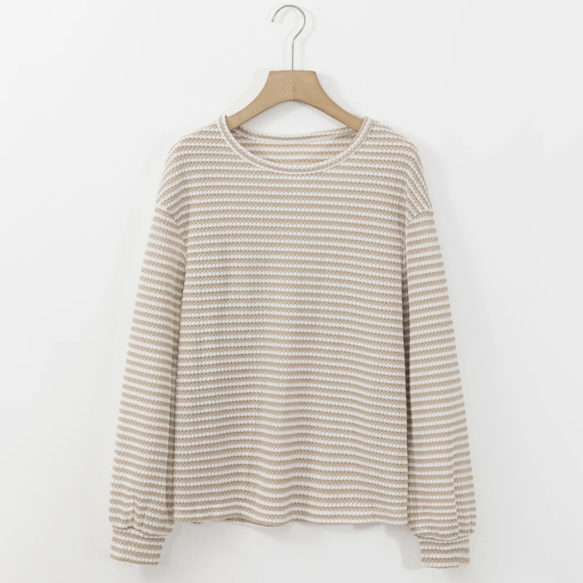 Striped long-sleeve sweater on a wooden hanger against a white background.