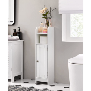 A slim white bathroom cabinet with a small door at the bottom and an open shelf above, holding a roll of toilet paper and decorative items like a vase with flowers and a candle. It's positioned on a patterned black and white floor next to a sink.