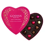 Heart-shaped box of Godiva chocolates in pink packaging with assorted chocolate pieces inside, including heart-shaped varieties.