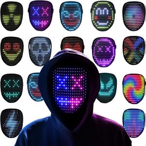 A person is wearing a hooded sweatshirt and a mask with LED lights that can display various digital patterns and designs across the mask's surface. Several LED masks with different illuminated colors and expressions surround the central figure.