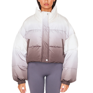 A cropped puffer coat with a monochrome ombre design transitioning from white at the shoulders to gray and dark brown at the waist, featuring a high collar and snap-button closure.