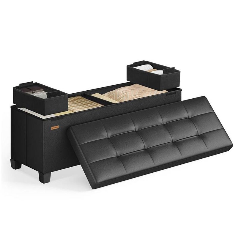 A black storage ottoman with a tufted removable lid reveals interior compartments divided into sections, with two smaller boxes on top for organizing items like blankets and other accessories.