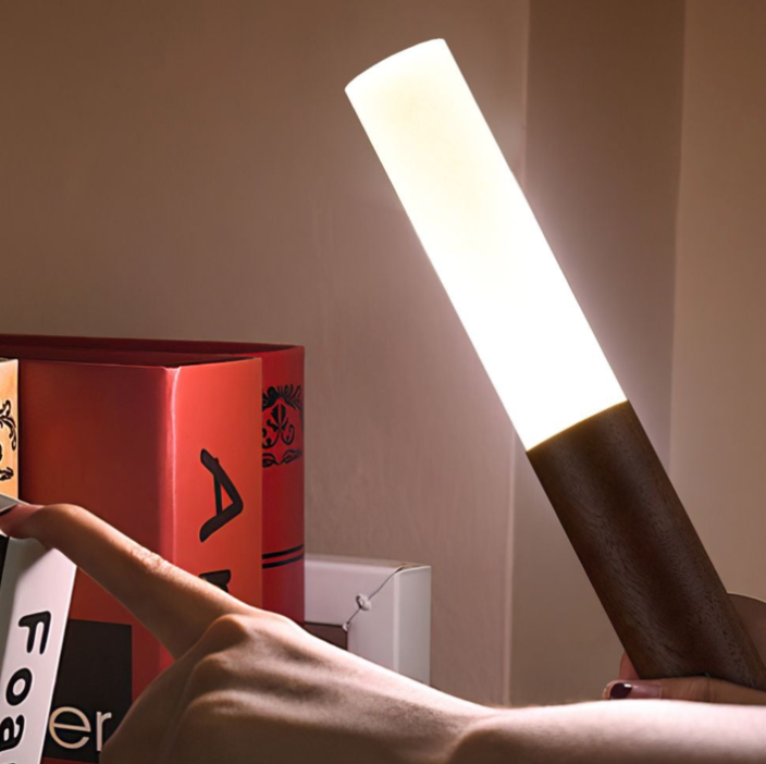 A lamp designed to resemble a handheld flashlight illuminating upwards, with a wooden handle and a bright, long bulb.