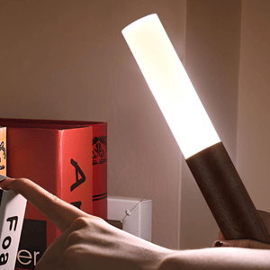A lamp designed to resemble a handheld flashlight illuminating upwards, with a wooden handle and a bright, long bulb.