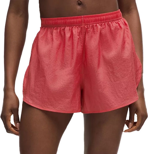 A person is wearing coral pink athletic shorts with an elastic waistband.