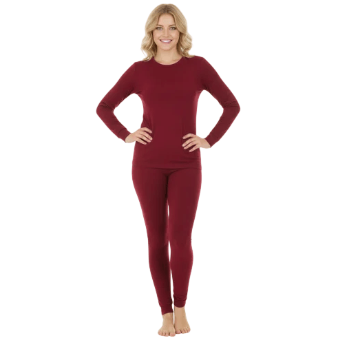 A woman is wearing a long-sleeve, burgundy thermal set consisting of a top and fitted pants.