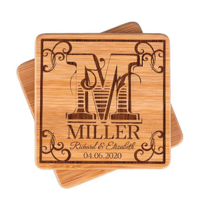 Wooden coasters engraved with the letter \“M,\“ the name \“Miller,\“ and the date \“04.06.2020,\“ along with the names \“Richard & Elizabeth,\“ featuring decorative scrollwork.