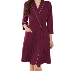 Women's lightweight robe in burgundy with white piping, features a wrap belt, three-quarter sleeves, and front pockets.