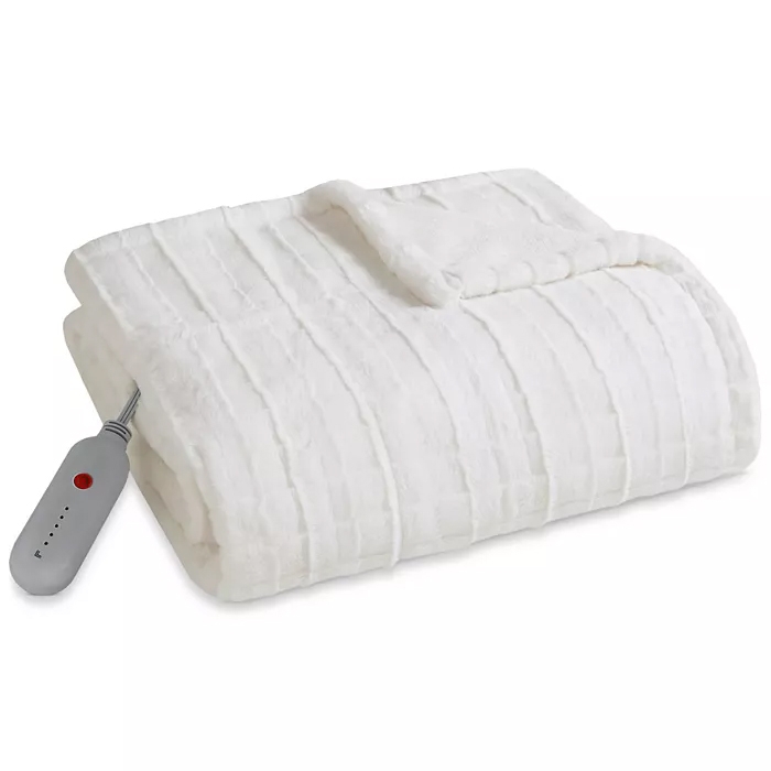 A white Sharper Image heated throw with a striped pattern and an attached remote control for adjusting heat settings.