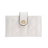 A white quilted wallet features a gold letter \“C\“ on the snap closure tab.