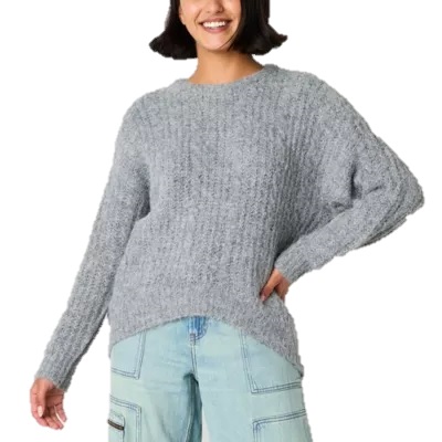 A person wearing a cozy, textured gray sweater with light blue cargo pants.