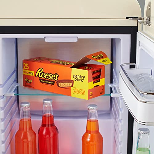 A box of 25 Reese's Peanut Butter Cups in fun-size packs is placed in a mini fridge, alongside bottled orange drinks.