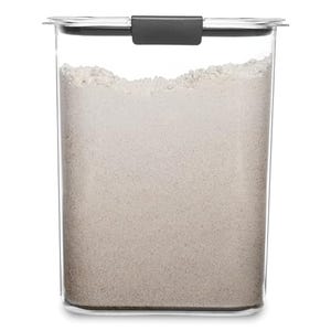 A clear rectangular container with a black handle on the lid, filled with a white powdery substance, possibly flour or sugar.